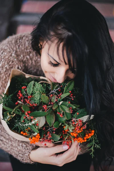 Young woman holding paper bag with ingredients for xmas wreath