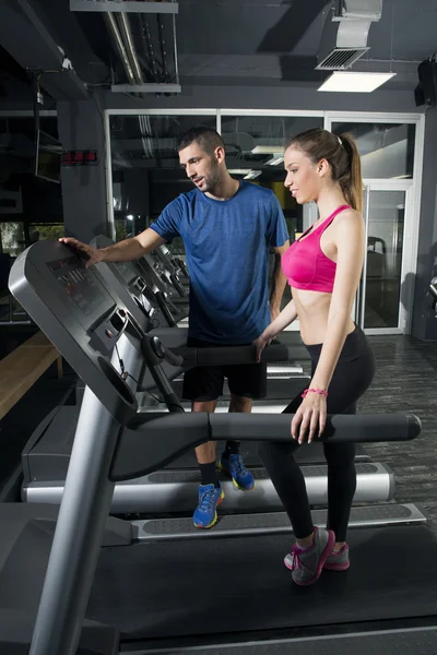 Young woman on treadmill, with instructor