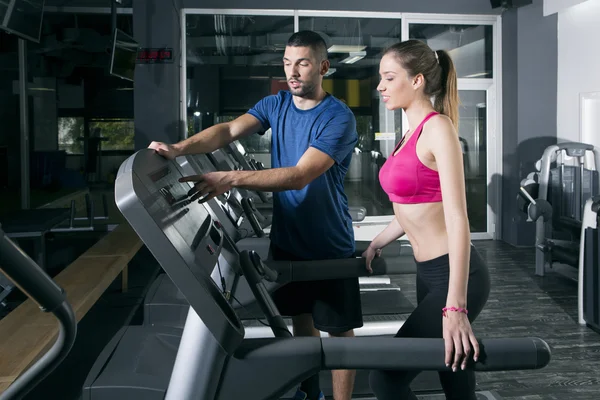 Young woman on treadmill, with instructor