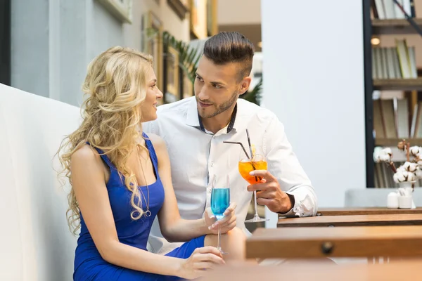 Beautiful couple at the bar drinking cocktails