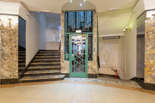 Interior of a corridor with passenger lift and marble stairs