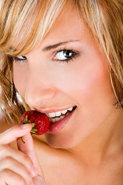 Beautiful woman biting a strawberry