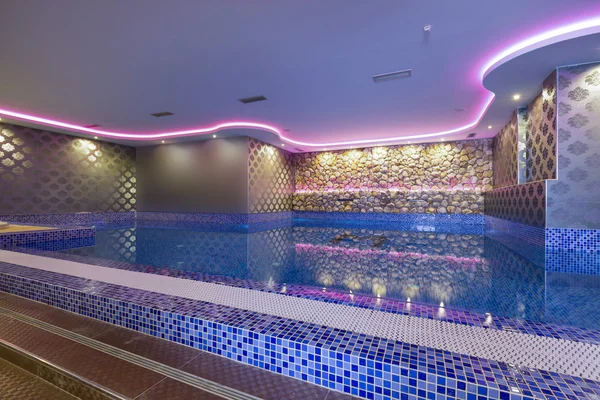 Indoors pool with colorful lights at spa center