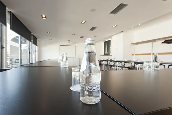 Bottled water and glass on conference room table
