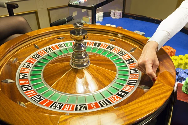 Croupier spinning the roulette wheel at casino