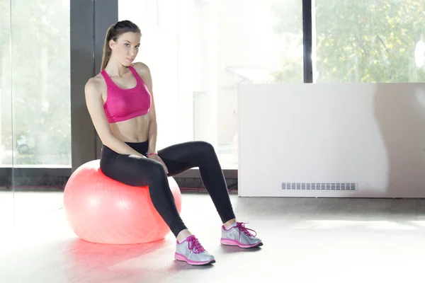 Young woman sitting on the exercise ball