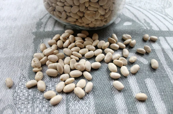 Dried white beans in a glass jar on the table