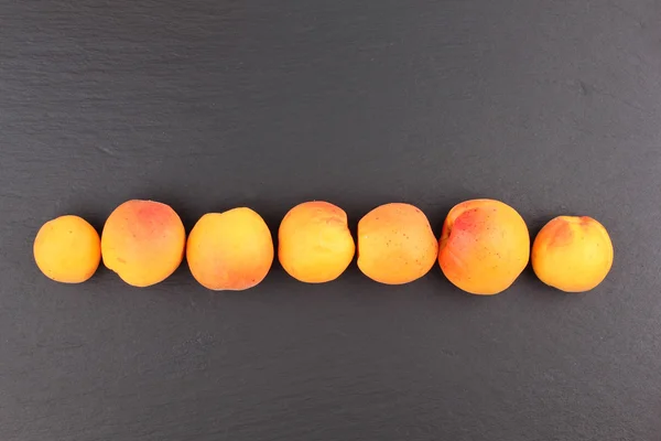 Fresh apricots on line isolated on blackboard