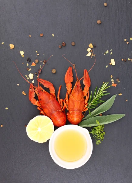 Delicious fresh lobster on dark vintage background. Seafood with aromatic herbs, spices and vegetables - healthy food, diet or cooking concept