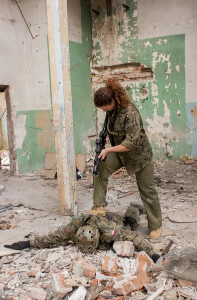 Hostage and female soldier with gun