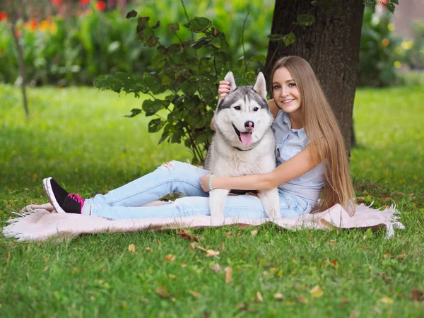 Attractive young woman hugs funny siberian husky dog