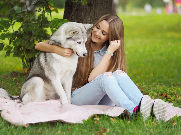 Attractive young woman hugs funny siberian husky dog