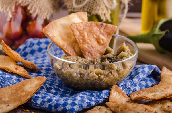 Homemade tortilla chips with garlic and eggplant dip