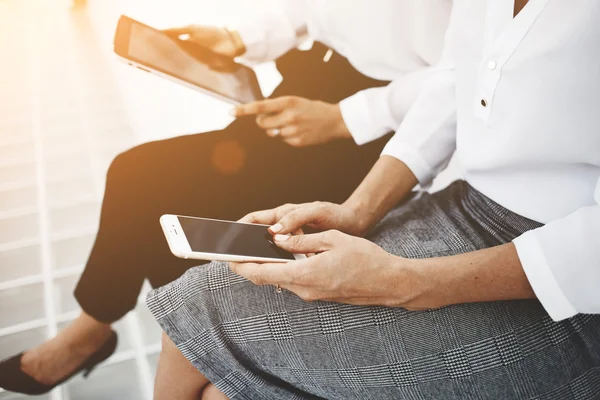 Female are using cell telephone and digital tablet