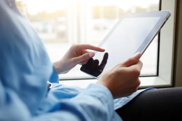 Closely image of teenager is playing games on portable touch pad, while is riding in the tram.