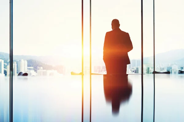 Silhouette of man banker looking in window