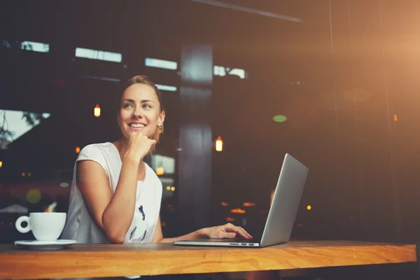 Charming happy woman student using laptop computer to prepare for the course work