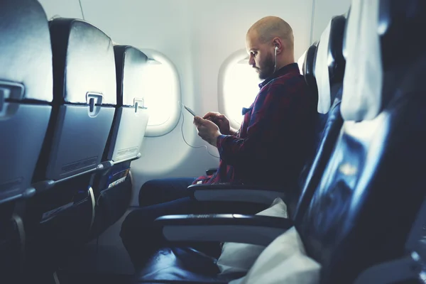 Man with mobile phone in airplane