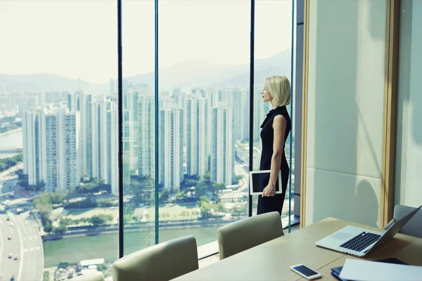 Successful woman CEO looking in window