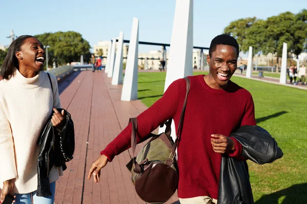 Friends having a great time together, two college friends laughing having good time, african couple smiling each to other at beautiful day two students smiling at college campus, happy people laughing