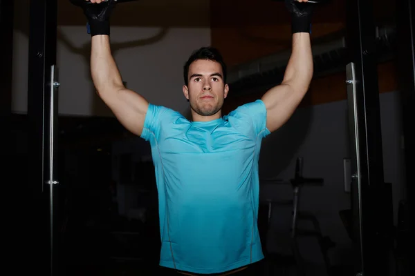 Athlete doing pull up exercise at gym