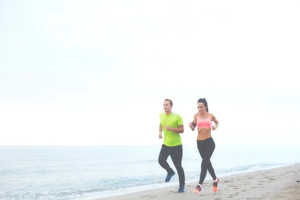 Runners jogging along the sea