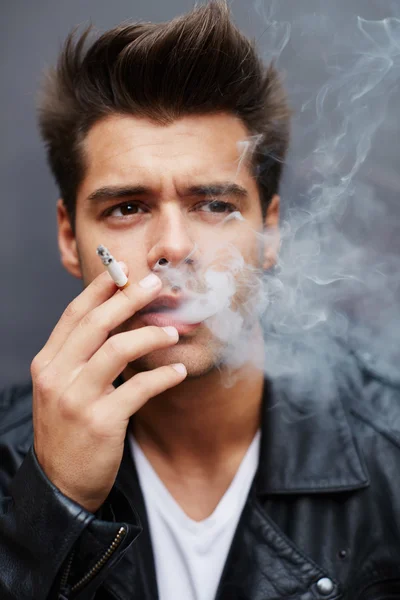 Model smoking cigarette and exhaling the fume