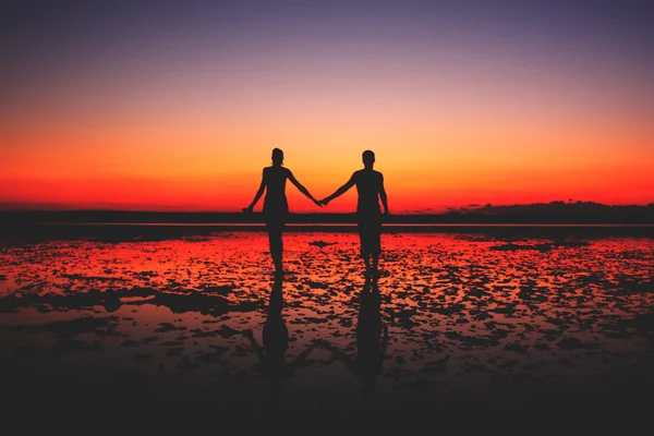 Couple in love holding hands at sunset