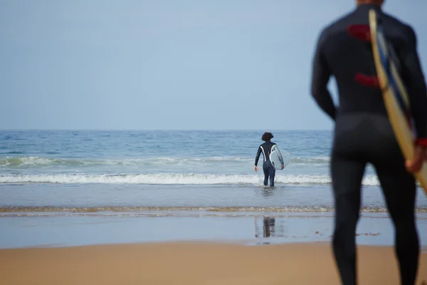 Male surfers carrying their surfboards
