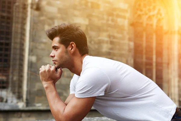 Man resting chin on clasped hands