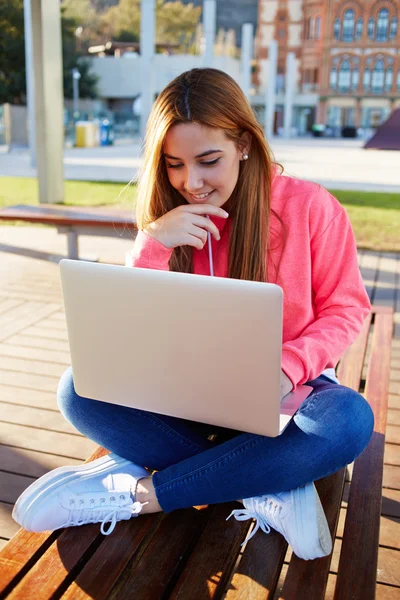 Female student sitting with open laptop computer