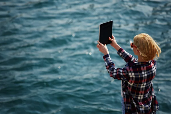 Woman taking picture with a digital tablet