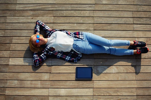 Woman enjoying sunshine while lying on the wooden pier