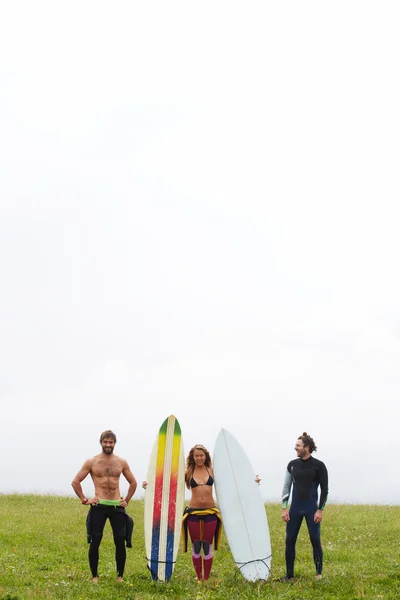 Young surfers standing on top mountain hill
