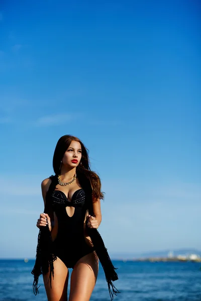 Young woman in beach dressed in black bikini