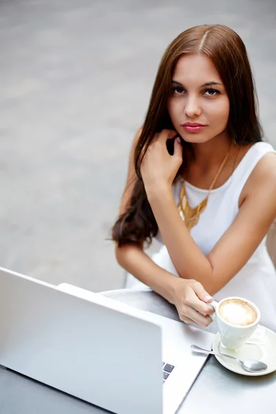 Teen working on her laptop at a bistro