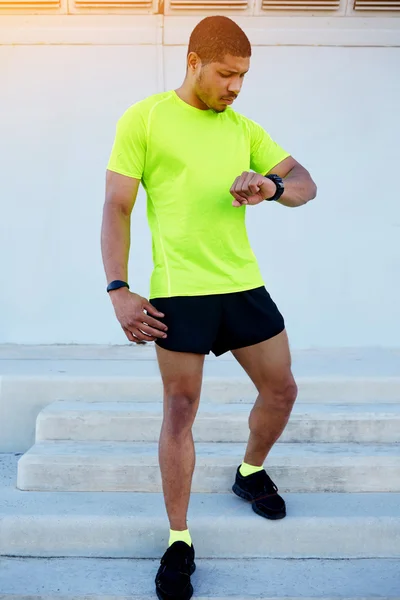 Male runner looking at his watch