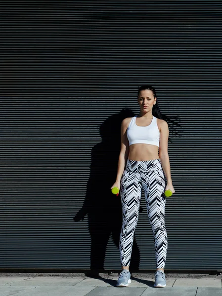 Woman holding weights with hands down