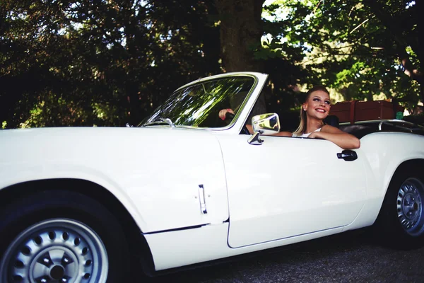 Wealthy woman sitting in her luxury cabriolet