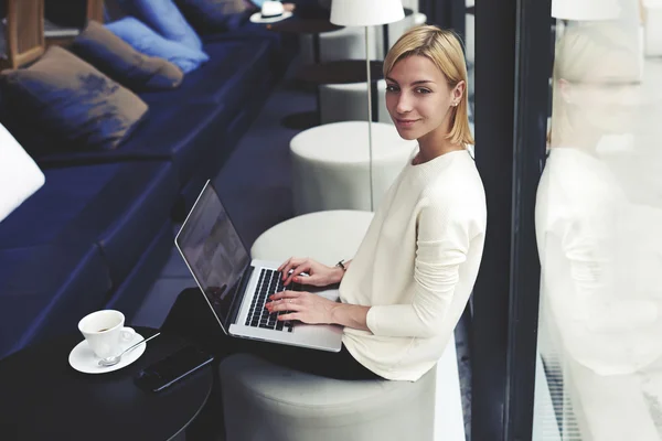 Woman with open laptop in coffee shop