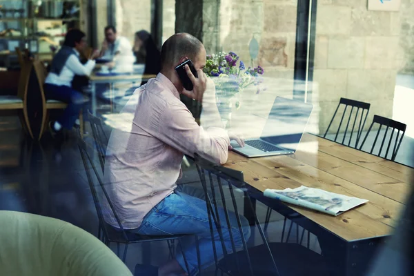 Businessman using laptop computer and phone