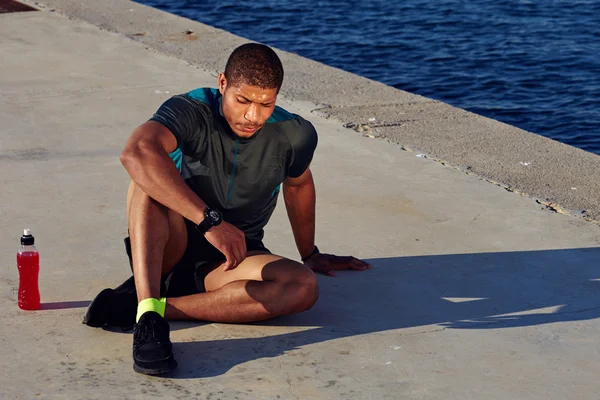 Male runner sitting on the road