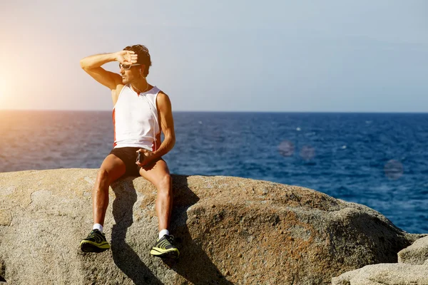 Male athlete relaxing after exercise