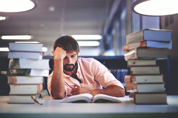 Young man studying hard in a library