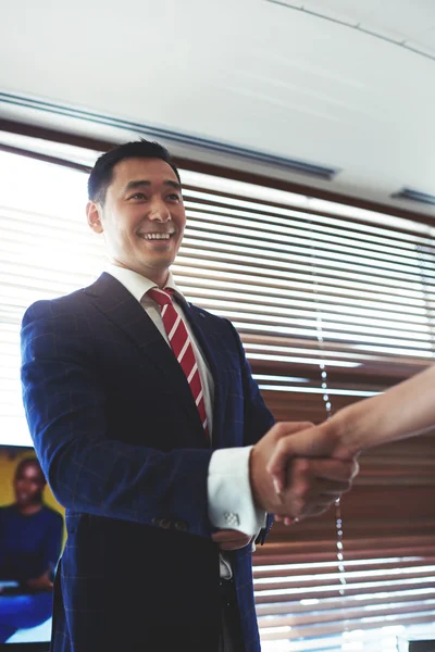 Smiling asian businessman shaking hands
