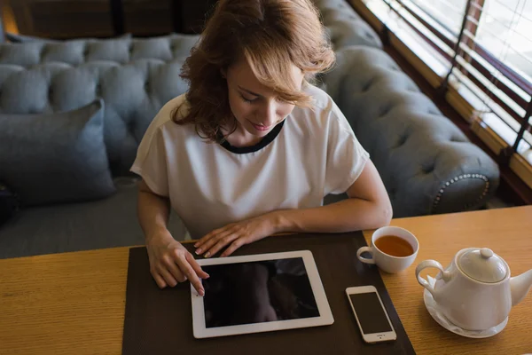 Woman using her touch pad in cafe