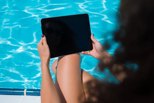 Female in bikini with touch pad near pool