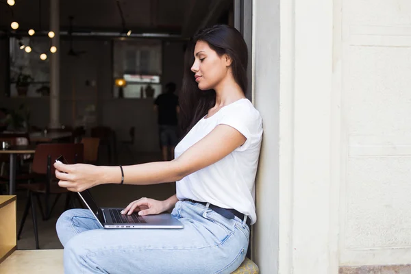 Young hipster girl working on her net-book