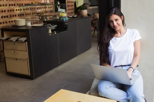 Young hipster girl working on her net-book