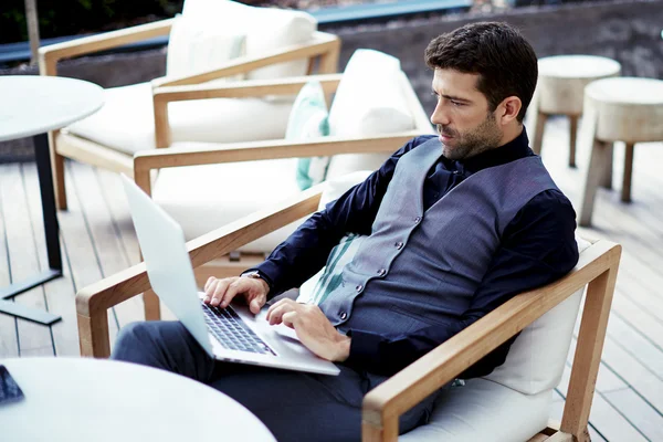 Businessman working on laptop at restaurant terrace